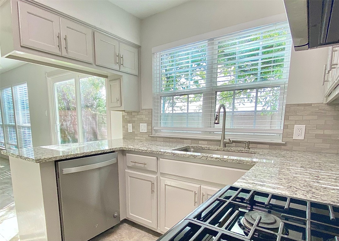 a kitchen with granite countertop a sink and a window