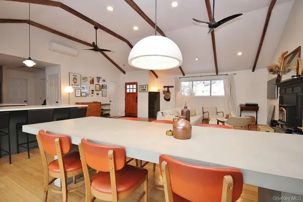 a kitchen with stainless steel appliances kitchen island granite countertop a table chairs and a refrigerator