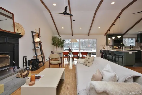 a kitchen with stainless steel appliances kitchen island granite countertop a table chairs and a wooden floor