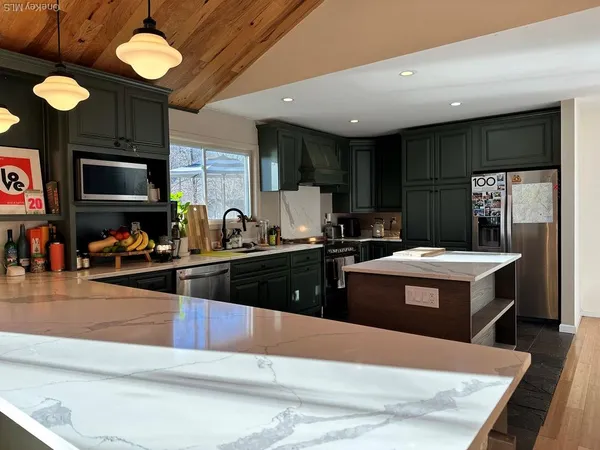 a kitchen with stainless steel appliances granite countertop a sink a stove and a refrigerator