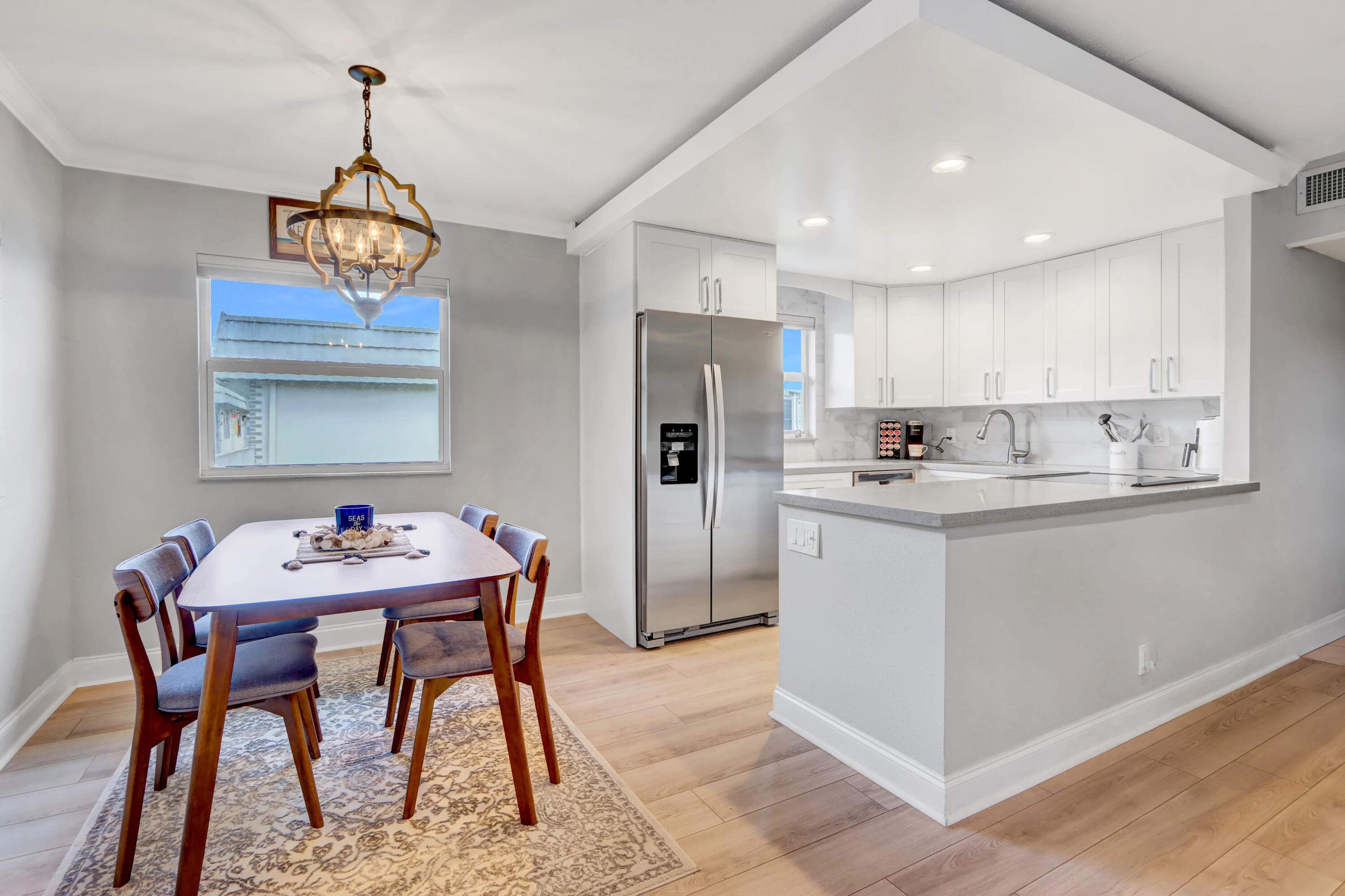 508 Monaco Way Delray Beach, FL 33446 - Photo 3 of 36 a kitchen with stainless steel appliances granite countertop a dining table chairs and white cabinets