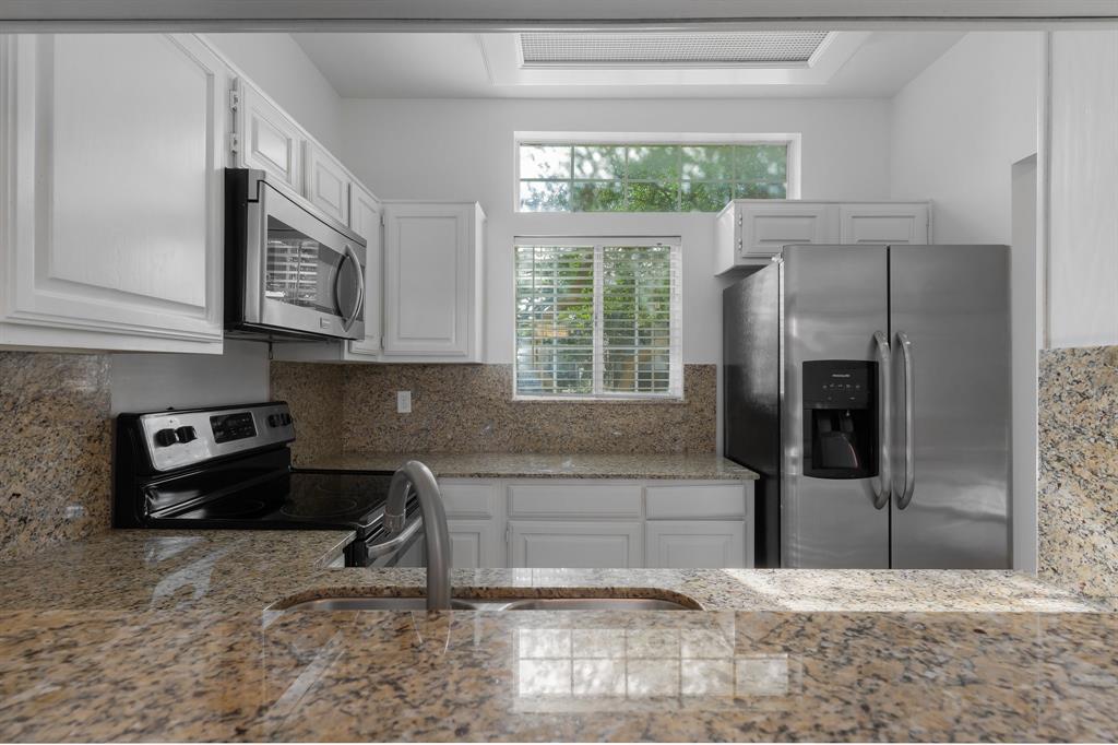 6303 Prospect Avenue, Unit B104 Dallas, TX 75214 - Photo 9 of 36 Kitchen features stainless steel appliances white cabinets, and granite counters & backsplash.