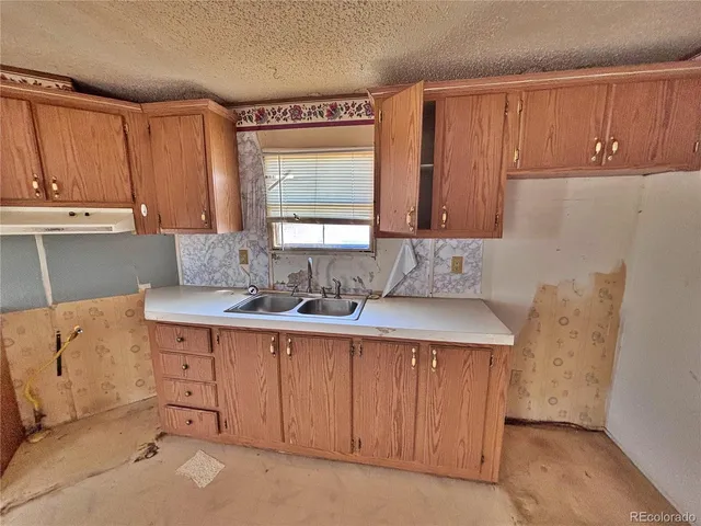 a kitchen with a sink window and cabinets
