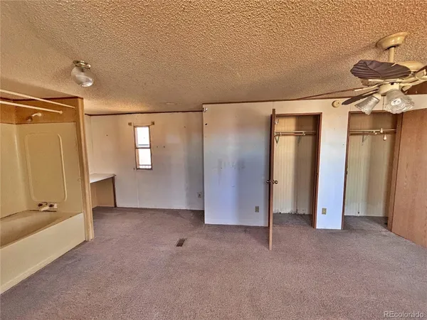 a view of a livingroom with a ceiling fan and refrigerator