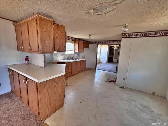 a view of kitchen with refrigerator cabinets and window