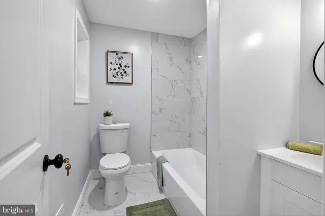 a white toilet sitting next to a bathroom sink and vanity