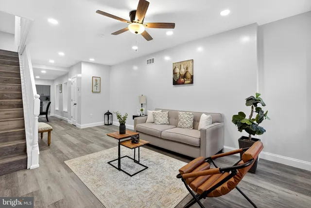a living room with furniture and a ceiling fan