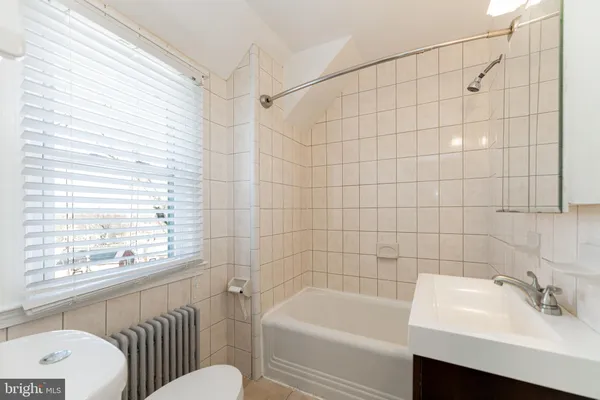 a bathroom with a sink a toilet a bathtub and shower