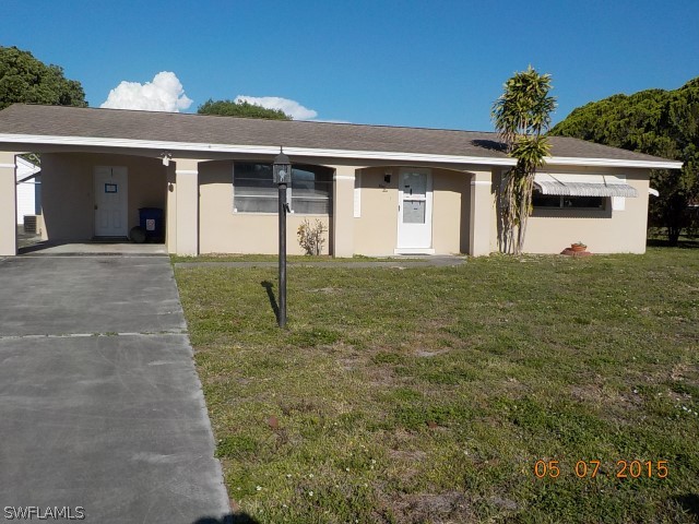 110 Rowland Road Lehigh Acres, FL 33936 - Photo 1 of 1 a front view of house with yard and trees