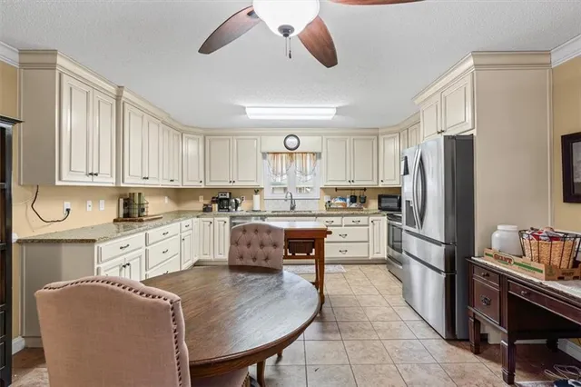 a large kitchen with kitchen island a large counter top space appliances and cabinets