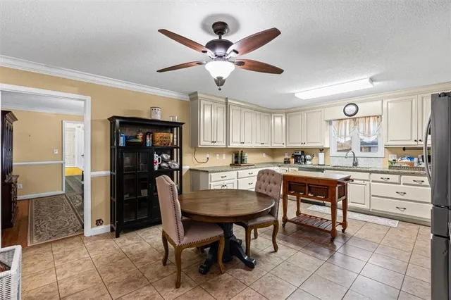 a kitchen with a dining table chairs and white cabinets