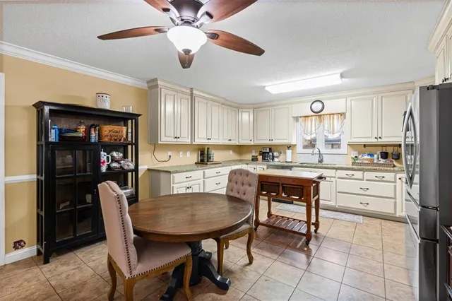a kitchen with a dining table chairs and refrigerator