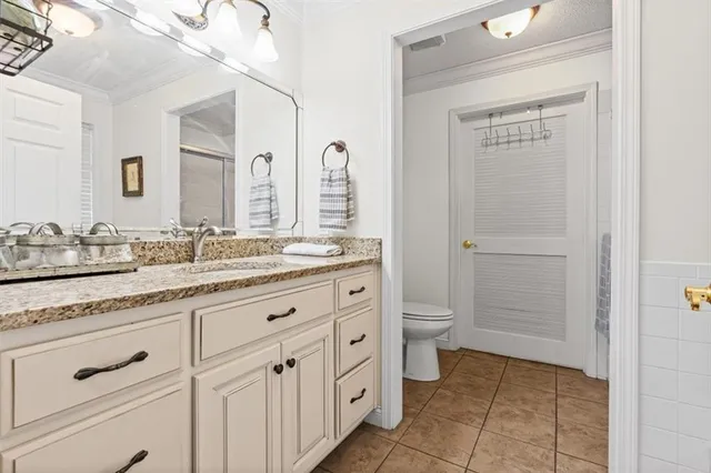 a spacious bathroom with a granite countertop sink a toilet and a mirror