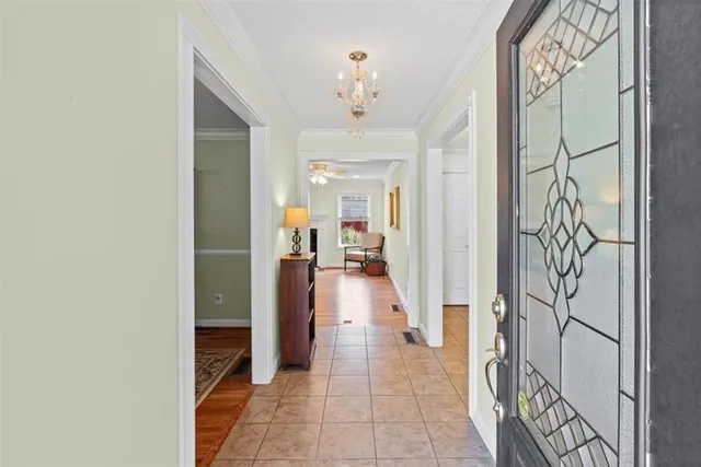 a hallway with a dining table and a chandelier