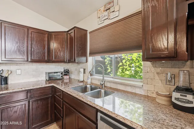 a kitchen with stainless steel appliances granite countertop a sink a stove cabinets and wooden floor