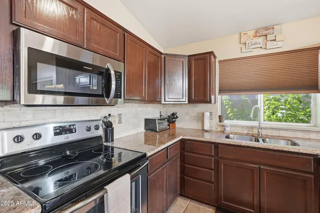 a kitchen with stainless steel appliances a sink stove and microwave