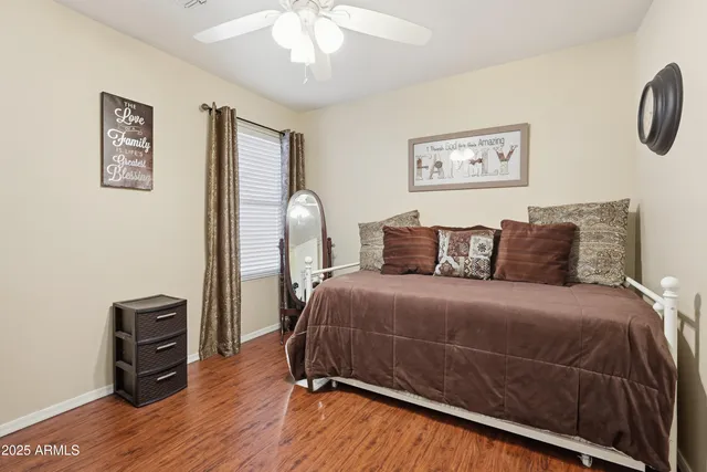 a bedroom with a bed painting on wall and a desk