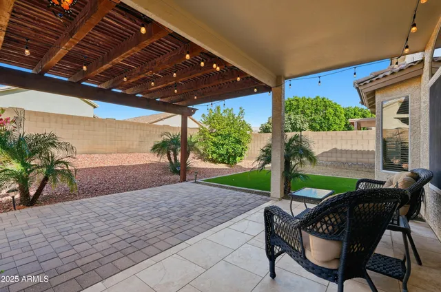 a patio with glass top table and chairs