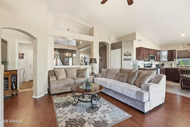 a living room with furniture and a view of kitchen