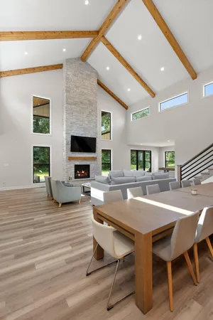 a living room with furniture a flat screen tv and a floor to ceiling window