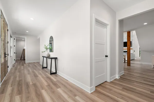 a living room with furniture wooden floor and kitchen view