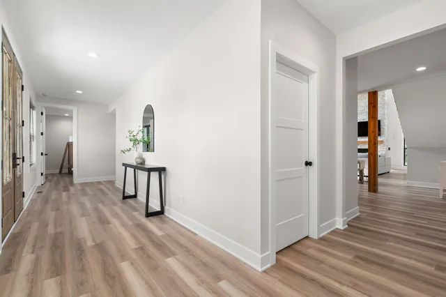a living room with furniture wooden floor and kitchen view