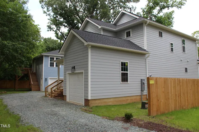 a view of a house with a yard and large tree