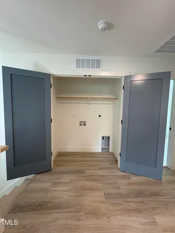 a view of an empty room with closet and a window