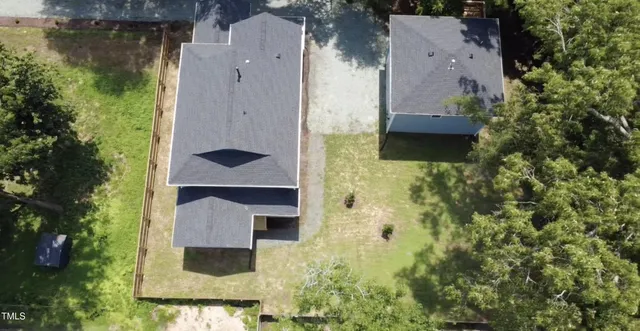 an aerial view of residential house with outdoor space and trees around