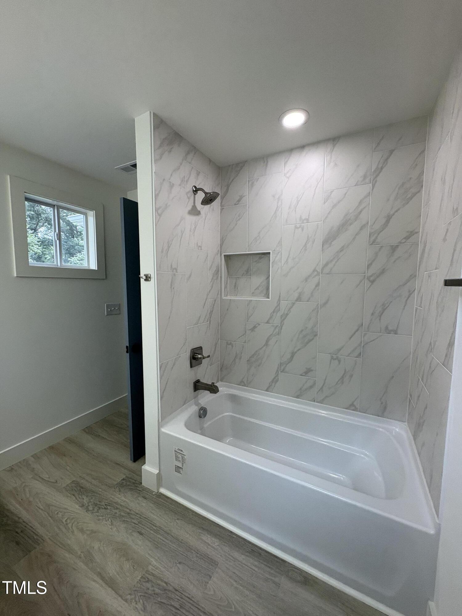 4511 Denfield Street Durham, NC 27704 - Photo 22 of 40 a bathroom with a bathtub and shower