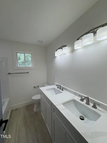 a bathroom with a sink toilet and window