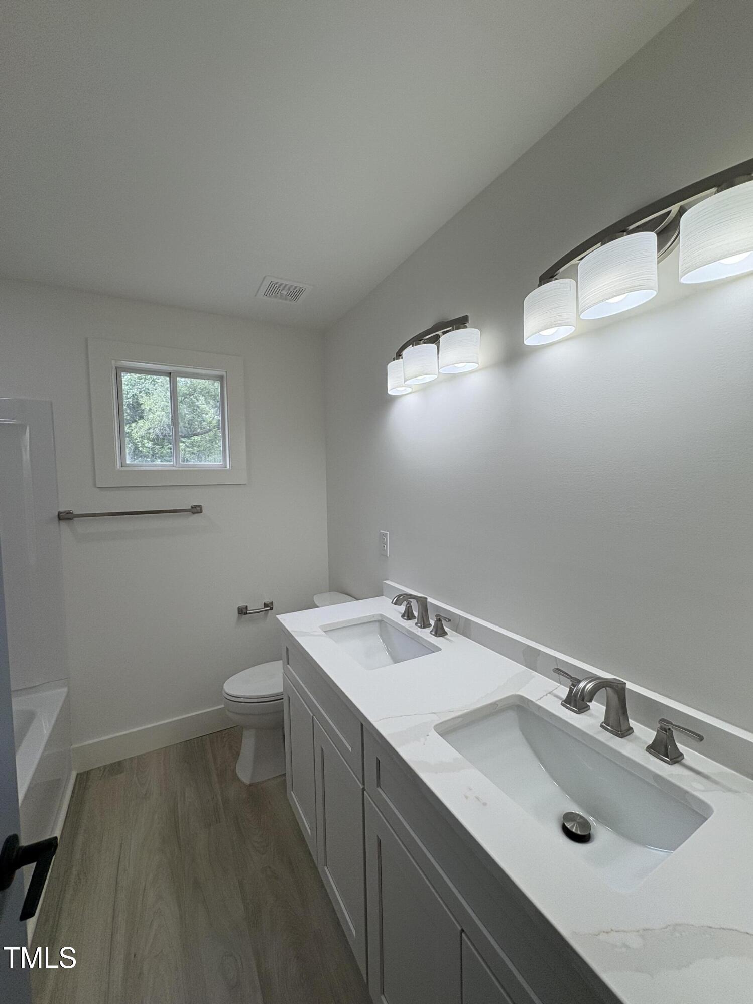 4511 Denfield Street Durham, NC 27704 - Photo 25 of 40 a bathroom with a sink toilet and window