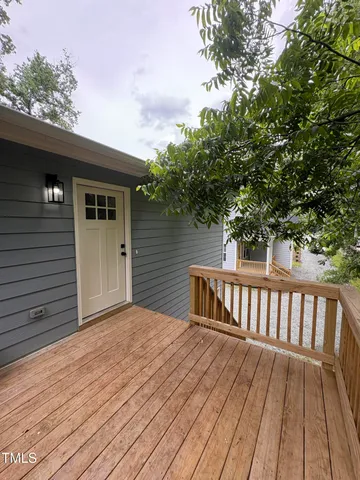 a view of backyard with wooden deck and floor to ceiling window