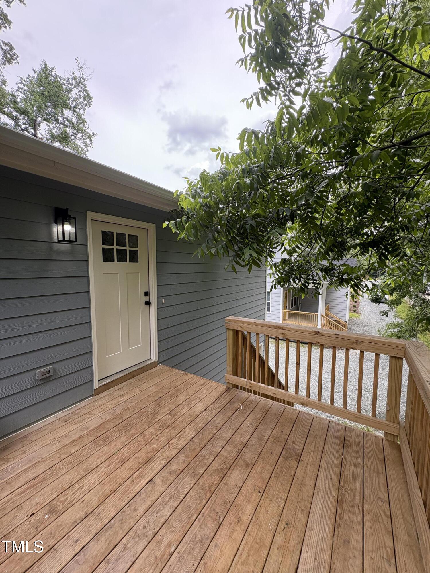4511 Denfield Street Durham, NC 27704 - Photo 30 of 40 a view of backyard with wooden deck and floor to ceiling window