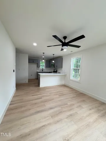 a view of kitchen with sink microwave and window