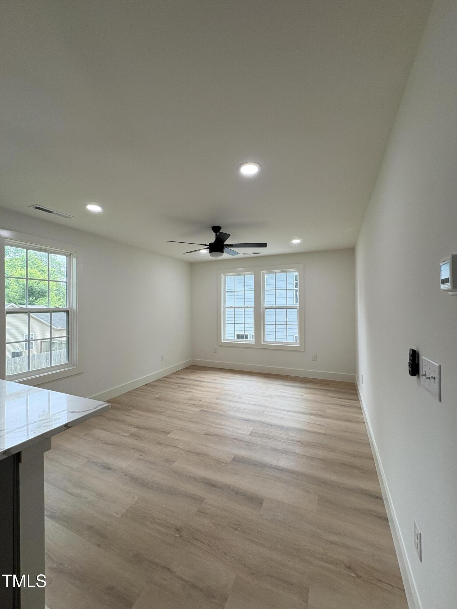 4511 Denfield Street Durham, NC 27704 - Photo 37 of 40 an empty room with wooden floor and windows