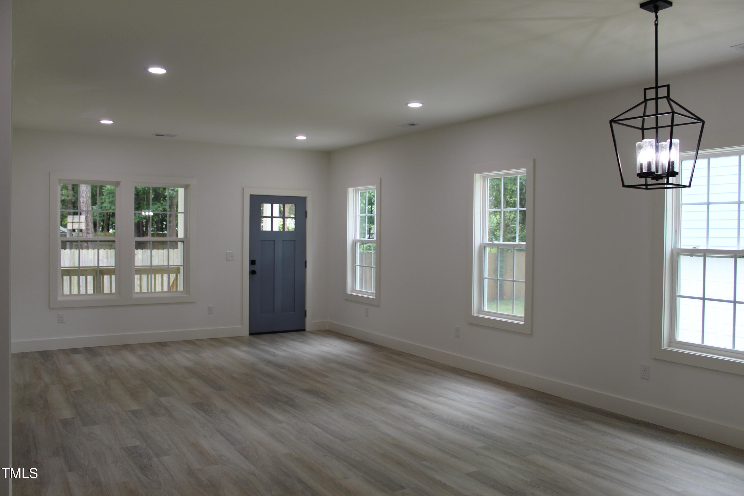 4511 Denfield Street Durham, NC 27704 - Photo 5 of 40 a view of an empty room with a window and wooden floor