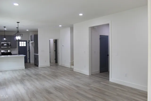 a view of a big room with wooden floor and a kitchen