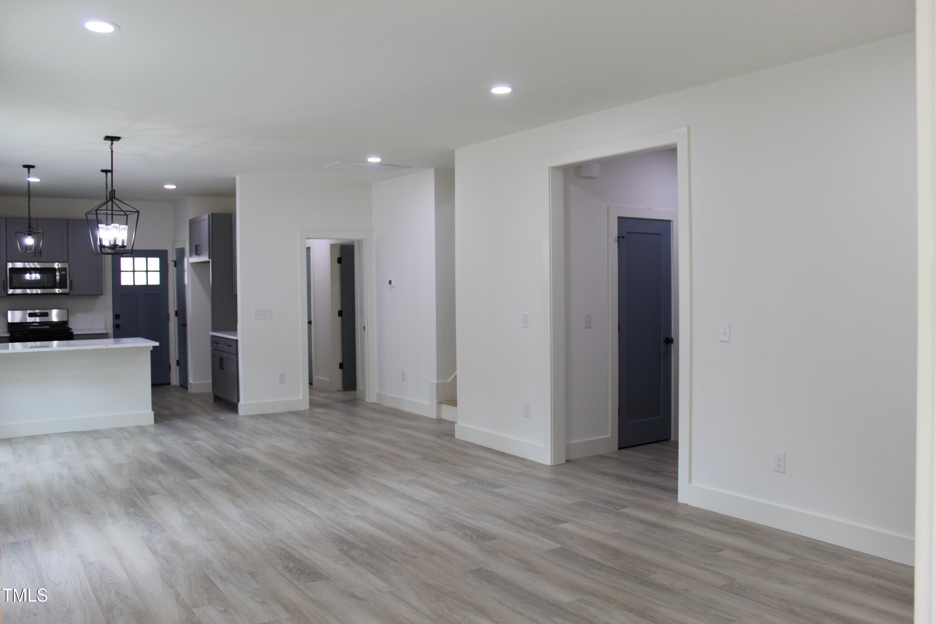 4511 Denfield Street Durham, NC 27704 - Photo 6 of 40 a view of a big room with wooden floor and a kitchen