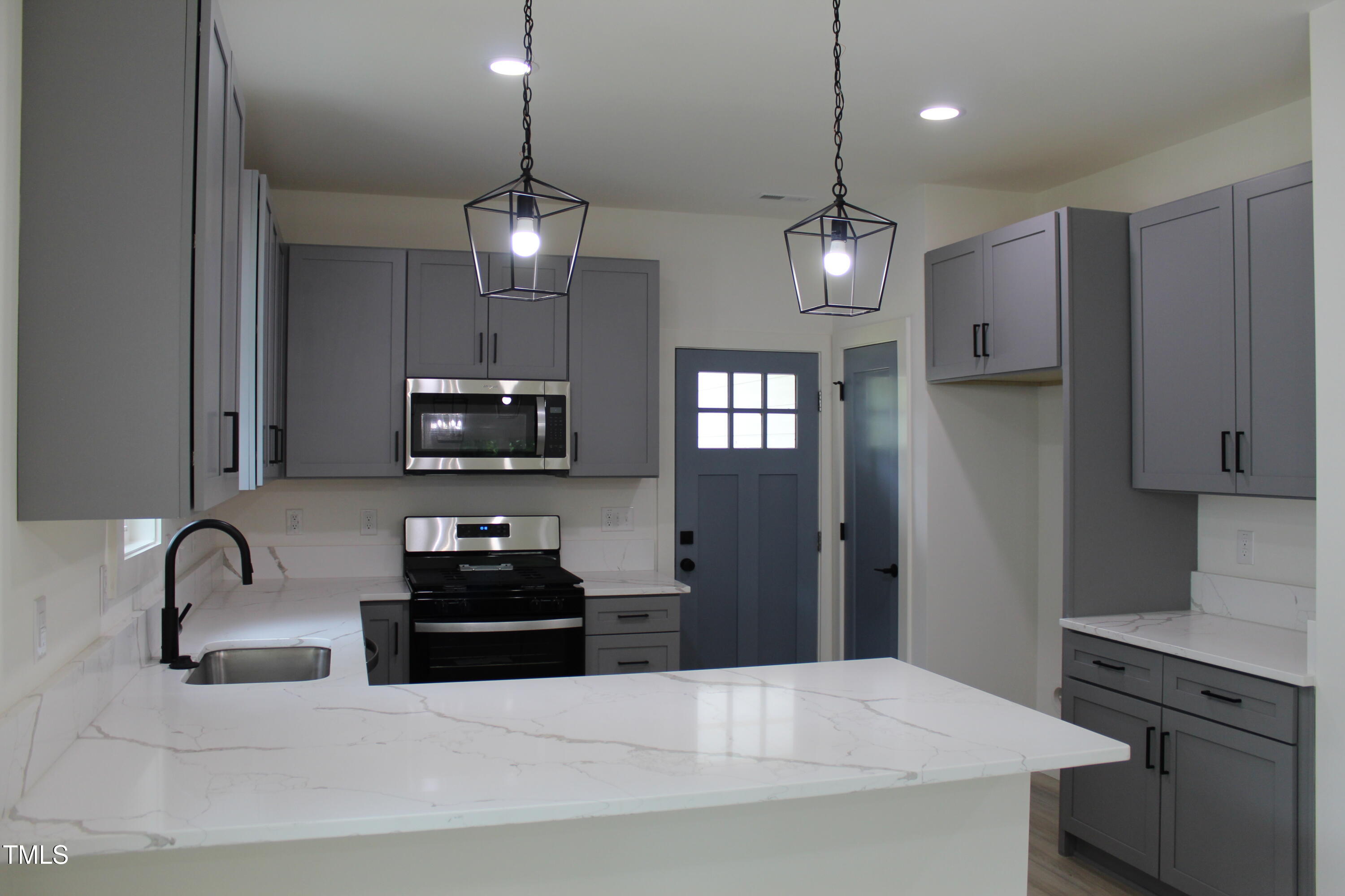 4511 Denfield Street Durham, NC 27704 - Photo 7 of 40 a kitchen with a refrigerator and a sink