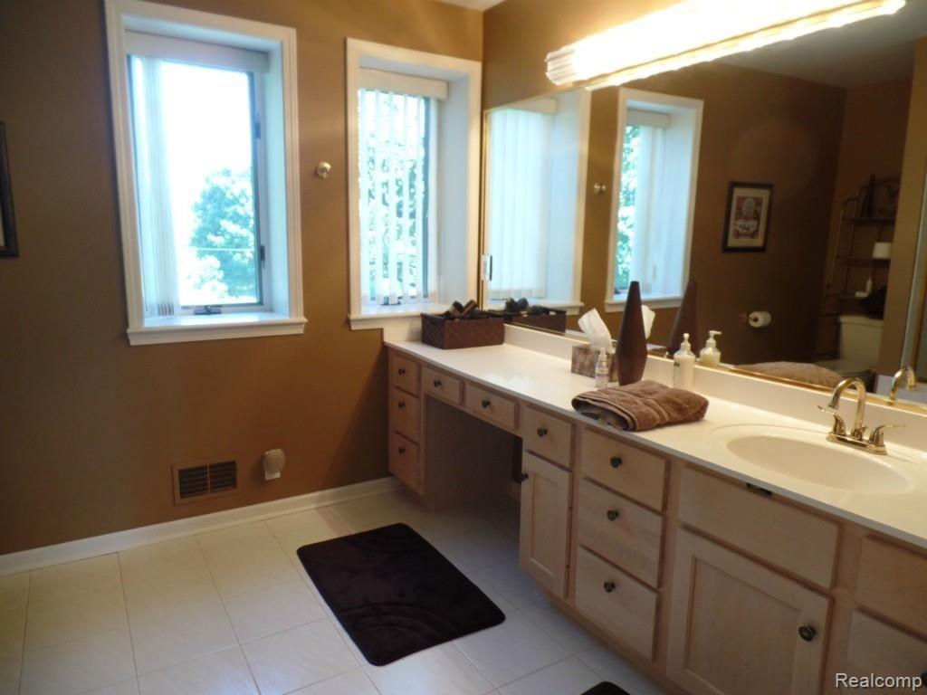 6340 Vassar Road Grand Blanc, MI 48439 - Photo 27 of 51 Extensive cabinetry and counter space are a hallmark of the master bathroom.