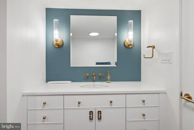 a bathroom with a sink vanity and mirror