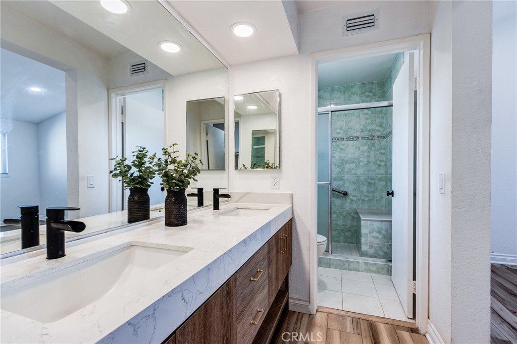 11721 Mt Sterling Court Rancho Cucamonga, CA 91737 - Photo 29 of 38 a bathroom with a granite countertop sink a large mirror and a shower
