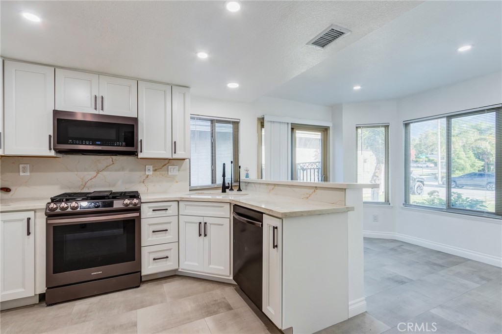 11721 Mt Sterling Court Rancho Cucamonga, CA 91737 - Photo 6 of 38 a kitchen with a stove and a microwave oven
