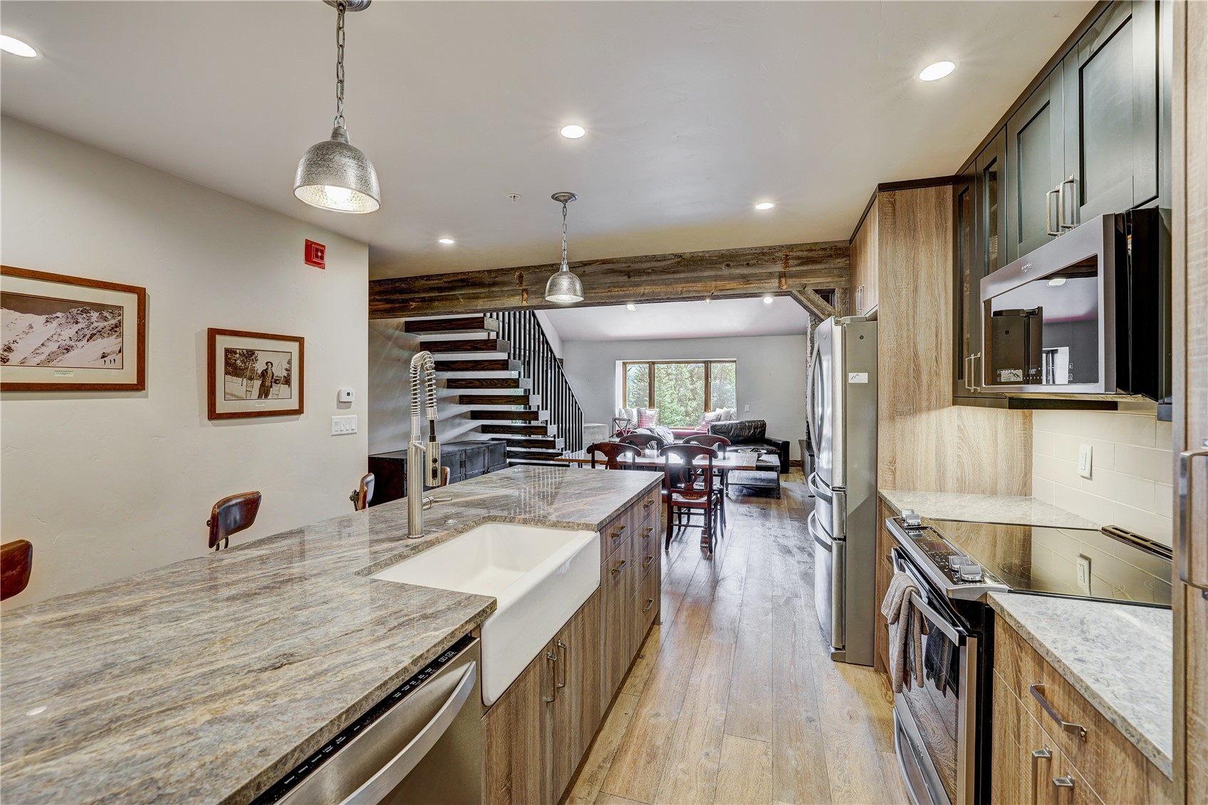 620 4 O Clock Road, Unit 336 Breckenridge, CO 80424 - Photo 7 of 29 Kitchen featuring stainless steel appliances, light wood-type flooring, light stone counters, backsplash, and hanging light fixtures