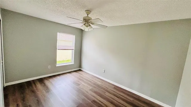 an empty room with a window and wooden floor