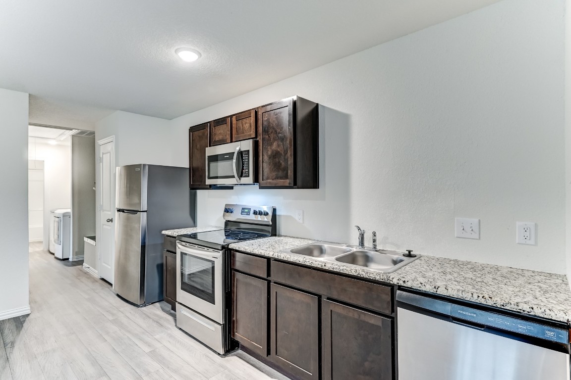 7925 Way Street, Unit A Houston, TX 77028 - Photo 11 of 29 a kitchen with stainless steel appliances granite countertop a sink stove and refrigerator
