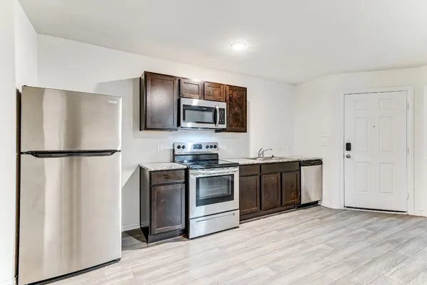 a kitchen with stainless steel appliances granite countertop a refrigerator stove and sink