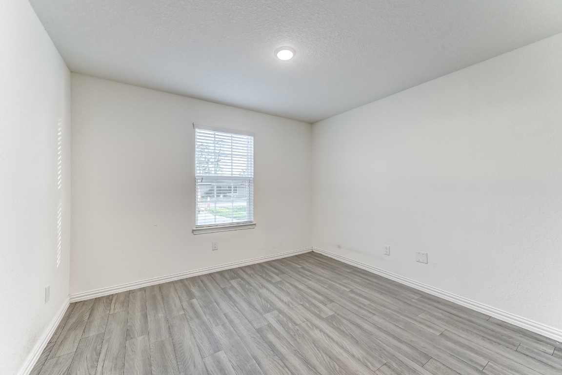 7925 Way Street, Unit A Houston, TX 77028 - Photo 13 of 29 an empty room with wooden floor and windows