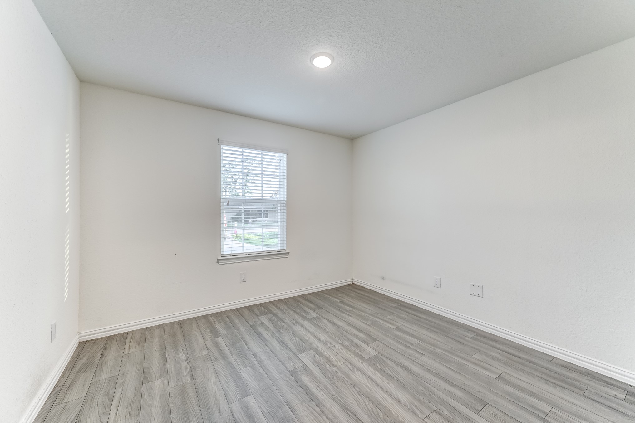 7925 Way Street, Unit A Houston, TX 77028 - Photo 13 of 29 an empty room with wooden floor and windows